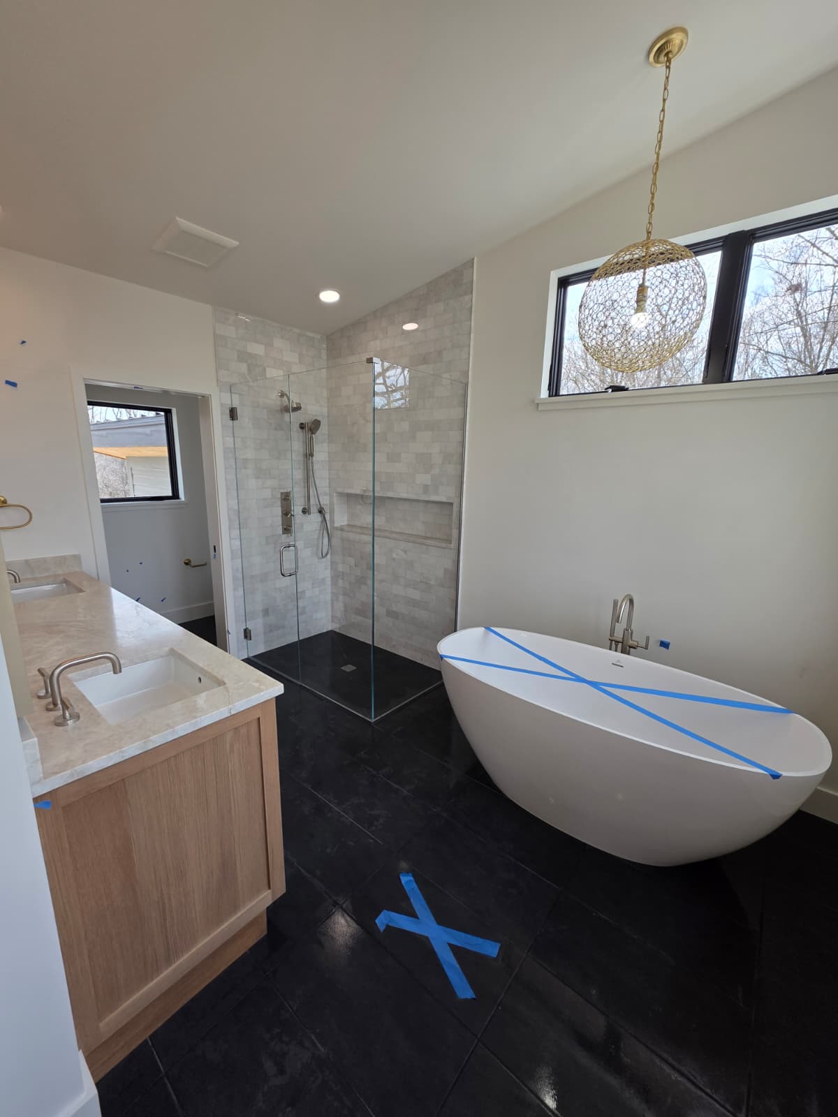 Primary bathroom with a freestanding tub, glass shower and white oak double vanity